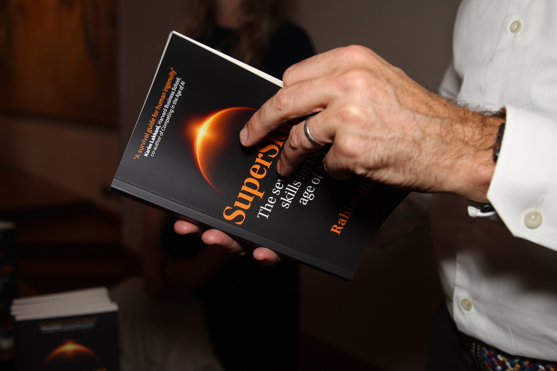 A guest holding an opened copy of SuperSkills, showing the cover endorsement