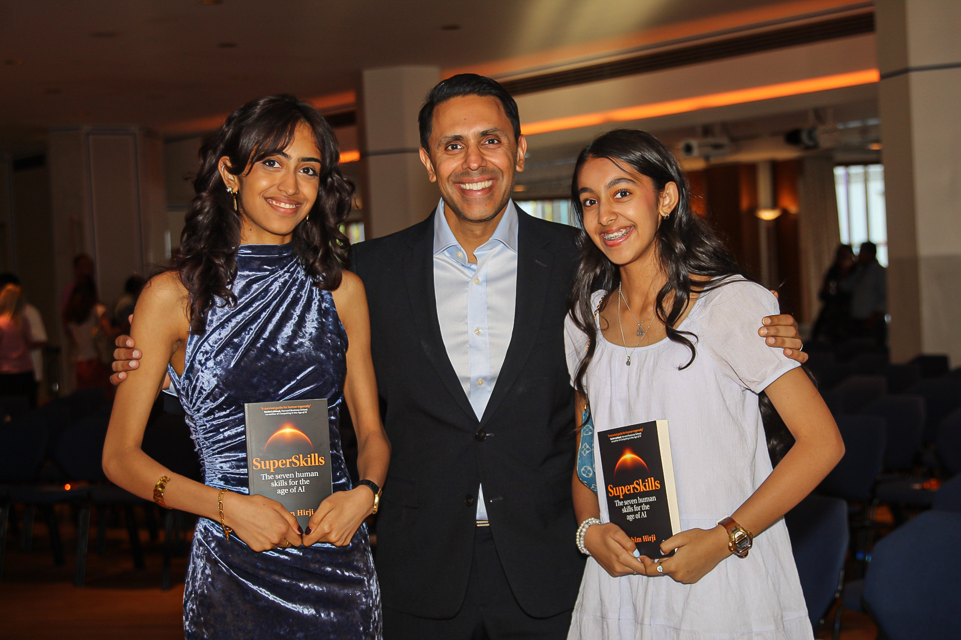 Rahim Hirji with his two daughters, each holding a copy of SuperSkills
