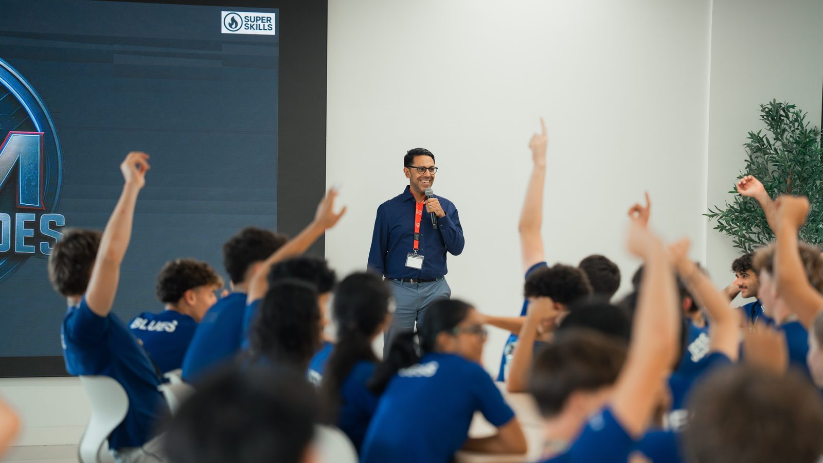 Secondary school pupils at JESS Dubai raising their hands during a SuperSkills keynote on AI and human capability
