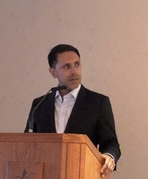 Rahim Hirji speaking at a podium
