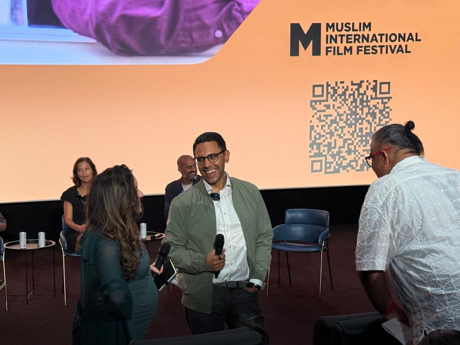 Rahim Hirji on stage with a microphone at the Muslim International Film Festival